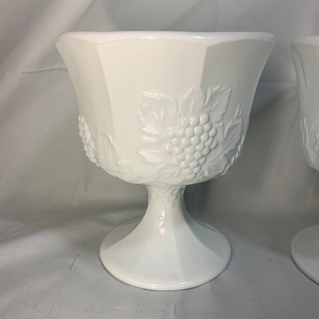 These are vintage white milk glass pedestal bowls in the "Harvest Grape" or "Colony" pattern by Indiana Glass Company....