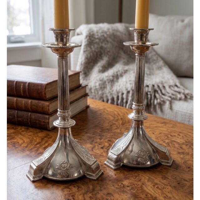 This elegant pair of vintage candlestick holders features a silver-plated finish with a charmingly tarnished patina,...