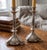 This elegant pair of vintage candlestick holders features a silver-plated finish with a charmingly tarnished patina,...