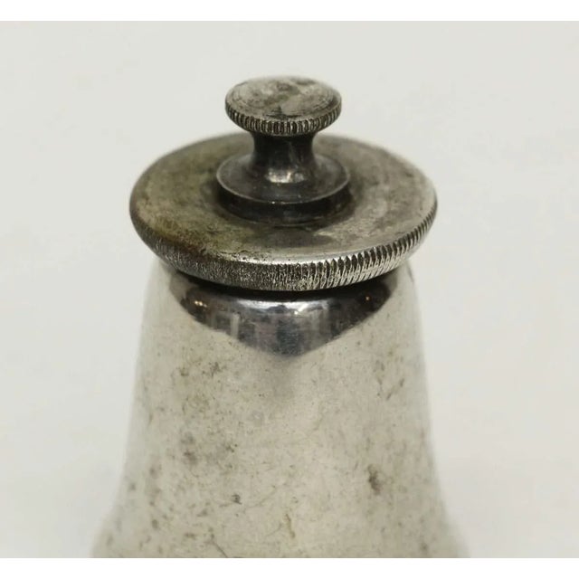 Imported metal pepper mill with silver plating. Inscribed on bottom. One available. The manufacturer and exact date of...