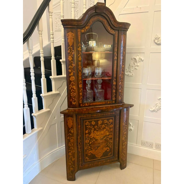 A superb antique display cabinet featuring exquisite marquetry and floral inlay, dating from the late. Crafted from rich...