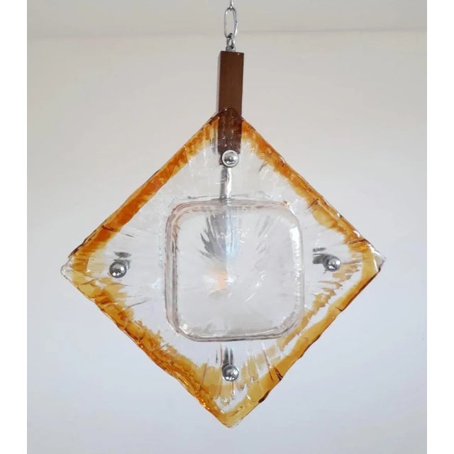 Vintage Italian chandeliers or pendants with double clear and amber Murano glass diffusers enclosing a single light bulb...