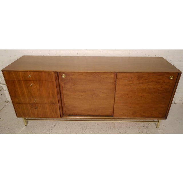 Beautiful vintage sliding door cabinet with brass trim and accents. Twelve total drawers make for a great bedroom dresser....