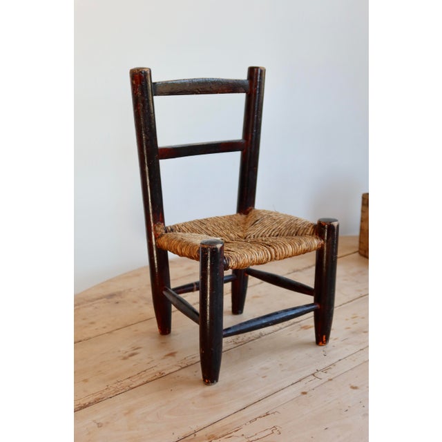 Adorable dark wood children's chair with a hand-woven straw seat. Its rustic and authentic look makes it a lovely...
