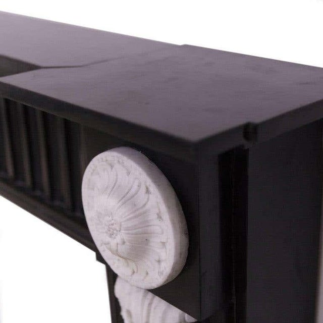 A beautiful 19th century marble fireplace mantelpiece. Carved in belgium black marble, with finely hand-carved white...