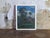 This captivating landscape depicts a peaceful village nestled among majestic trees beneath dramatic cloud-filled skies....