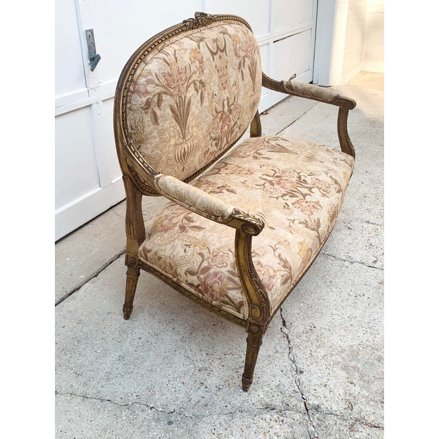 Gorgeous antique settee. Louis XVI style. Intricate gilded wood base with brocade fabric upholstery. The pictures don’t do...