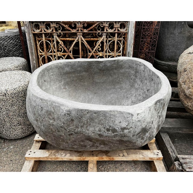Solid stone boulder with carved out center, creating a one of a kind giant bowl. Polished smooth inside with rough natural...