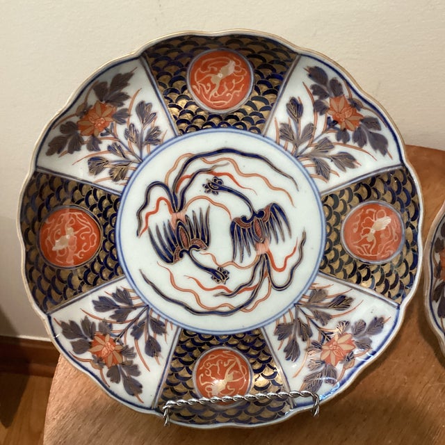 This product is a pair of antique Edo period Japanese Imari porcelain plates, hand-painted in vibrant colors with...