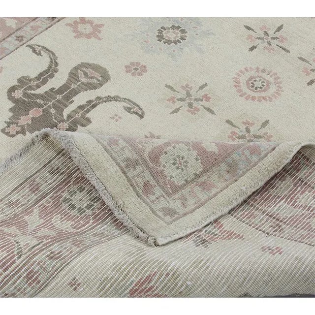 This traditional old handwoven Tabriz style area rug features an intricately rendered allover design embellished with a...