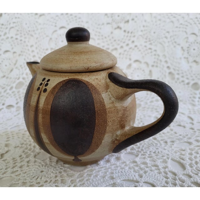 A Sgrafo Modern stoneware teapot that was made in Germany during the 1960s. Such an incredible piece. Measuring 9” w x 5...