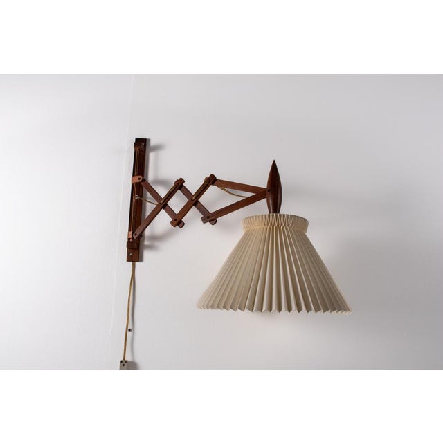 This scissor / sax wall lamp features a wooden adjustable arm that extends and folds back smoothly, making it both...