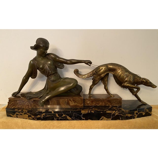 A stunning French Art Deco figural group depicting a Huntress and her Borzoi. The bronze has a beautiful warm patina and...