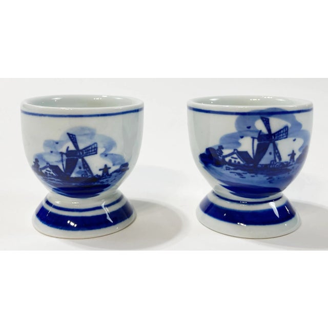 Pair of classic blue and white hand-painted Delft egg cups. Marked on underside. Natural age wear. No chips or cracks.