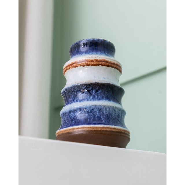 Shapely vintage vase by Strehla. The ceramic vase with blue and white striped gradient glaze fits perfectly into the Mid-...