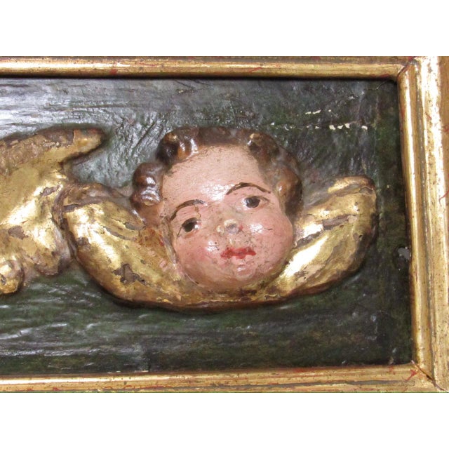 Antique Spanish Colonial hand carved wood panel with the heads of three winged putti or cherubs in high relief, c.1900 The...