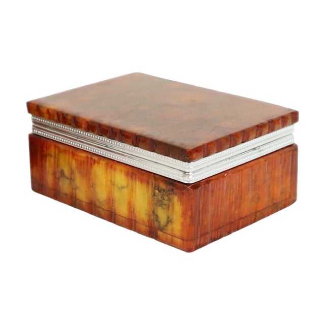 A stunning, high-quality smoking set comprising a heavy ashtray and a box, crafted from hand-carved orange alabaster by...