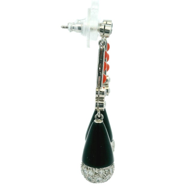 A pair of French Art Deco Revival drop earrings crafted in platinum, showcasing a sophisticated combination of vibrant red...