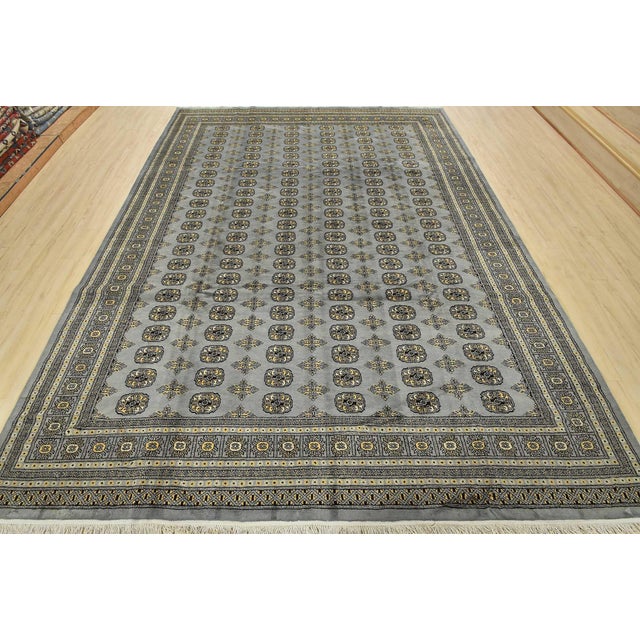 A tribal Bokhara rug hand-knotted with fine wool on a cotton foundation. This rug features rows of repeating medallions...