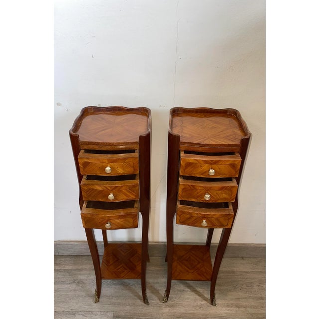 Pair of Louis XV style bedside tables in rosewood and native wood marquetry. They open with three drawers on the front...