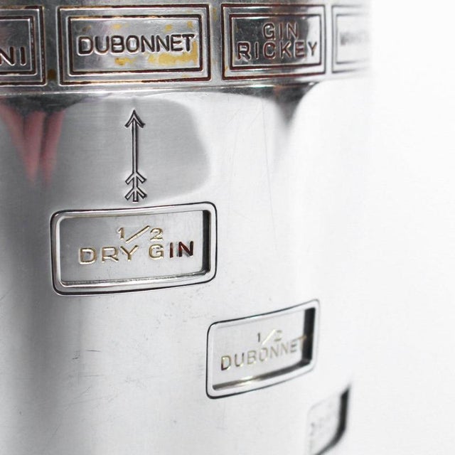 An Art Deco, silver plated and gilt recipe cocktail shaker. Integral strainer. O uter sliver plated cover revealing silver...