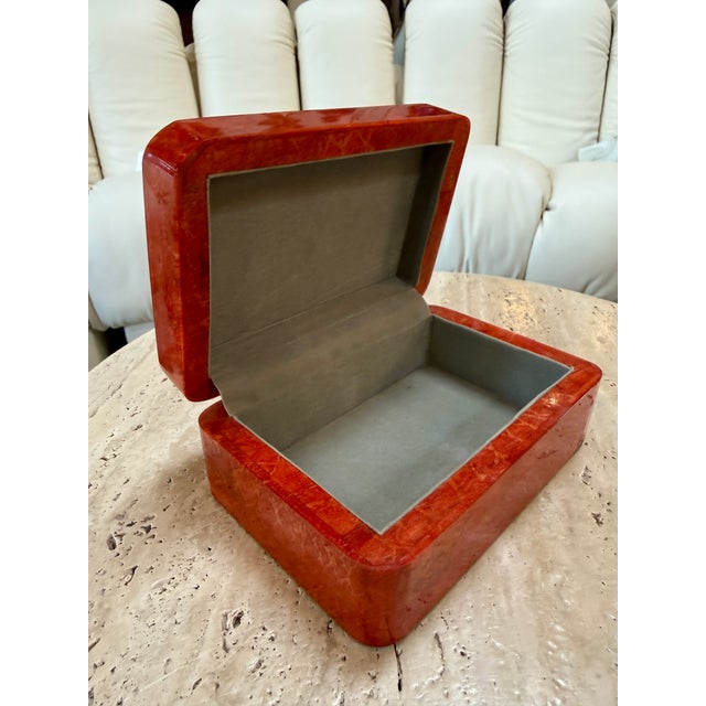 Elegant rectangular Italian decorative box featuring rounded corners and a richly mottled red lacquer finish. Its warm...