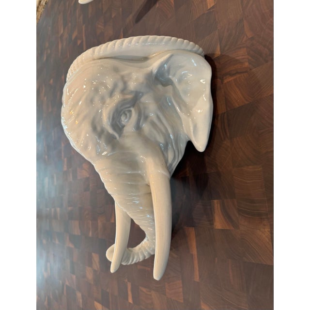 A near-pristine pair of vintage Italian white glazed ceramic elephant head wall brackets, beautifully sculpted with...