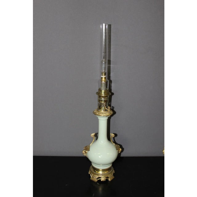 Pair of oil lamps in celadon green porcelain and bronze, lion head decoration, functional electrification, height without...