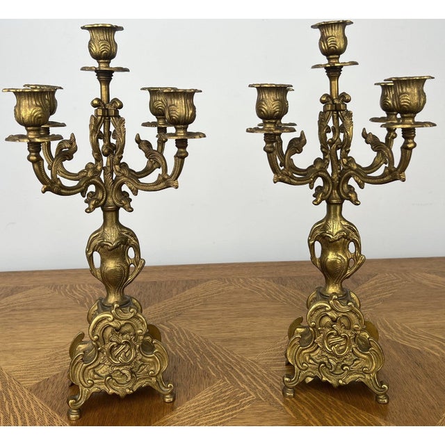 An elegant pair of Vintage brass candelabras featuring beautifully ornate five-arm candle holders with richly decorative...