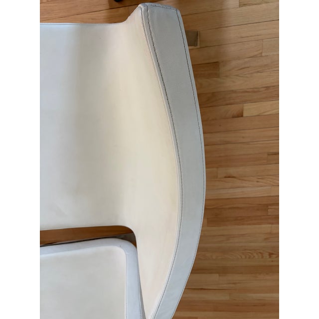 A pair of Stella Lounge Chairs by Blu Dot. Firm seat and back is upholstered with a sumptuous white leather. Thin and open...