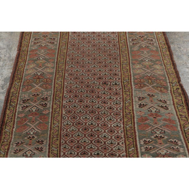 This 3x10 antique Persian runner, circa 1900-1920, is a striking addition to Rug & Kilim’s antique collection, hand-...