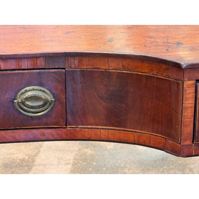19th century English mahogany server with a shaped front that curves inward at the center and bows out at each end. Three...