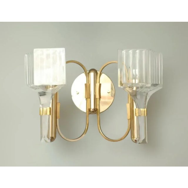 Italian wall lights with clear faceted glass diffusers mounted on circular golden structures / Made in Italy, circa 1960s...
