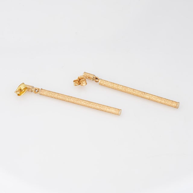 Fine detailed pair of gold bar barrel drop earrings crafted in 14k yellow gold (circa 1980s to 1990s). Each earring...