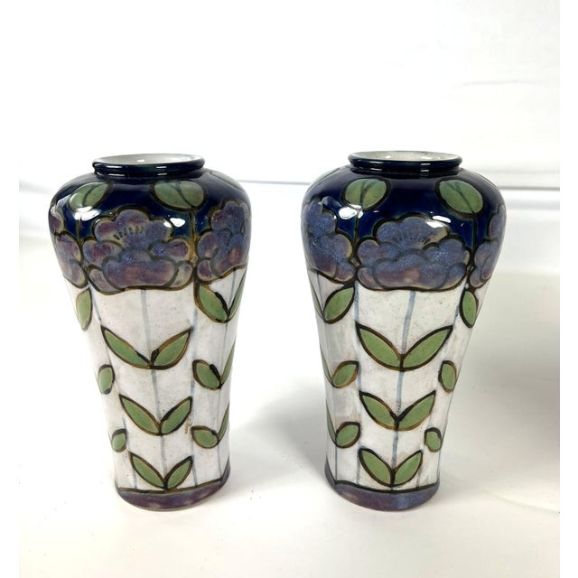The pair of Royal Doulton stoneware vases by Bessie Newbury, a ceramic artist working at Royal Doulton. The shouldered...