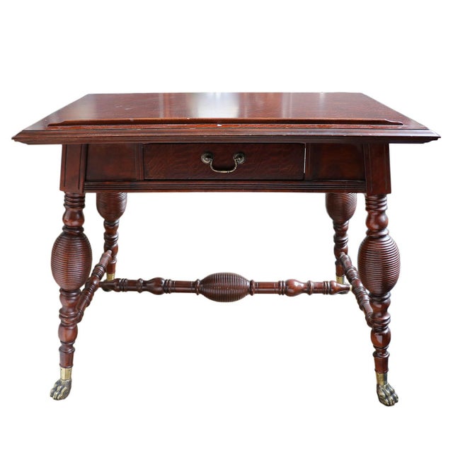 A 19th-century English-style drafting or writing table crafted from rich, dark mahogany. This highly functional piece...