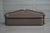 An elegant vintage-inspired sofa upholstered in warm taupe fabric, featuring a distinctive sculpted backrest with a...