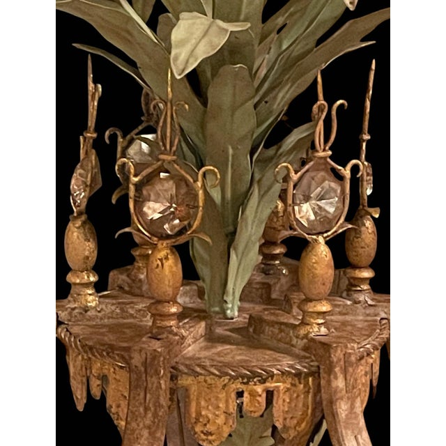 Exquisite tole chandelier by Currey & Co. Slender foliage sprouts from the column, surrounded by six faux candlelights....