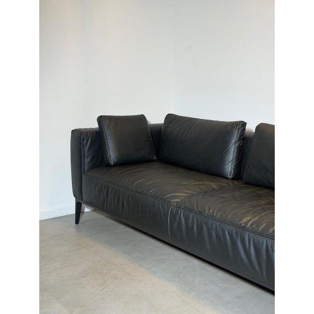Elegant contemporary sofa by indera , upholstered in supple black leather. The sofa features a clean architectural...