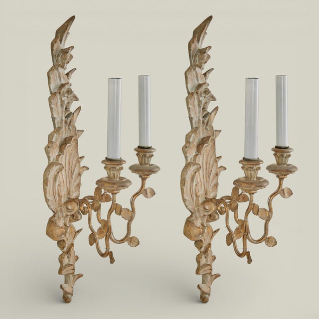 Pair of neoclassic antique Italian carved wood two light wall sconces with seashells and floral motifs having metal arms...