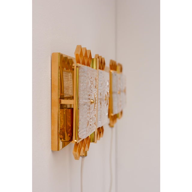 A pair of elegant crystal glass wall sconces designed by Carl Fagerlund for the prestigious Swedish glass manufacturer...