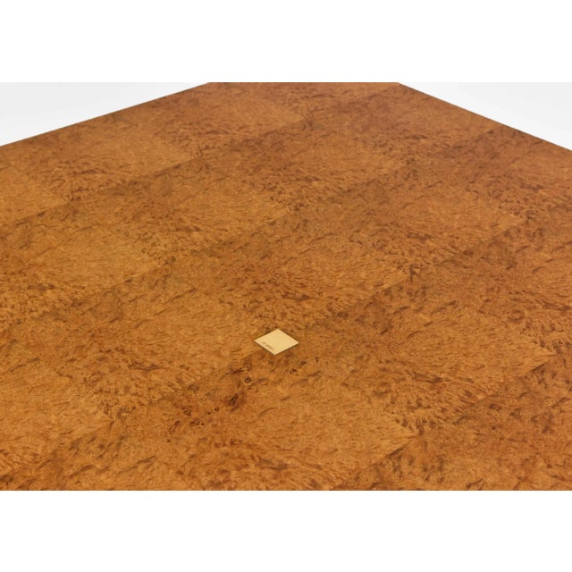 An impressive coffee table made of exotic Amboyna burl wood, with real gold lined edging and central gold maker's...