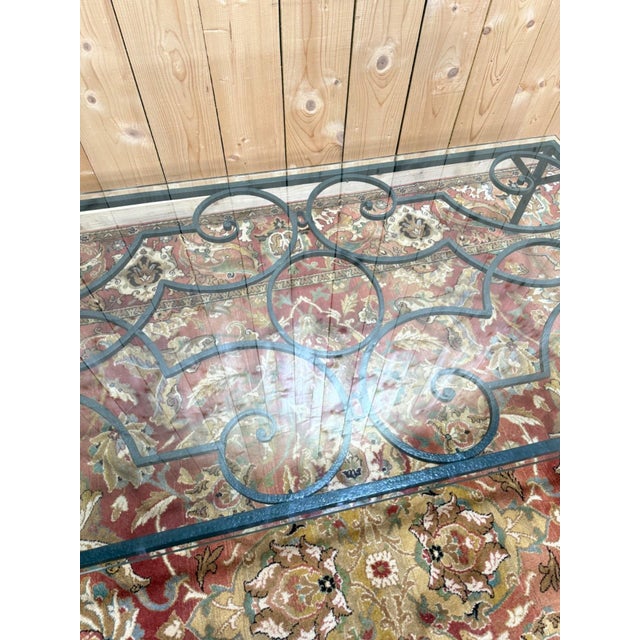 Coffee table in wrought iron with a thick glass top. The structure is characterized by meticulous ironwork with elegant...