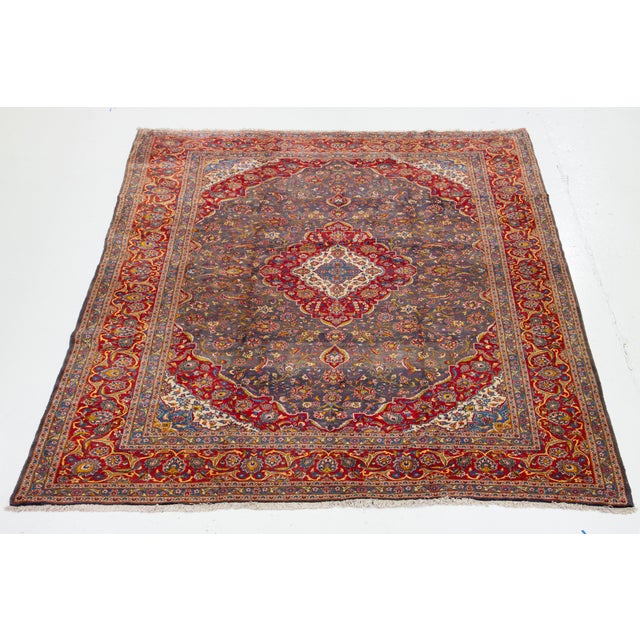 This Persian Kashan hand-knotted wool rug has a gray field and multicolor accents all over the motif. This rug measures...