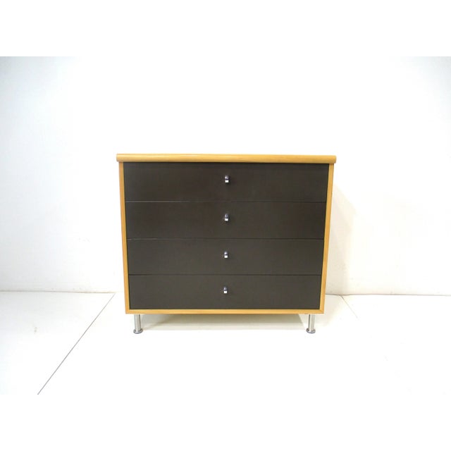 A four drawer birch wood Mid Century dresser with dark chocolate drawer fronts having U shaped chrome finger pulls . With...
