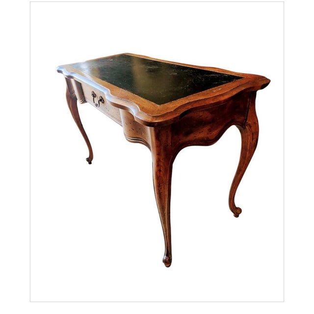 This is a French Provincial-style writing desk, specifically identified as a model by Globe Furniture. This characteristic...