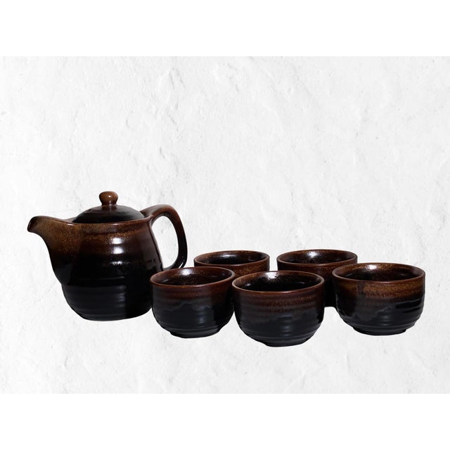 A richly glazed vintage Japanese tea service featuring one sculptural teapot with removable stainless infuser and five...