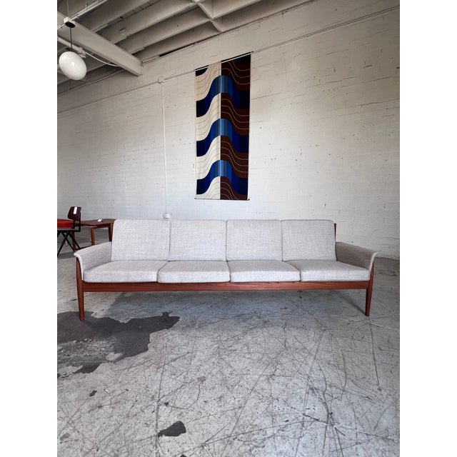 Newly upholstered mid century modern Danish teak sofa by Grete Jalk, featuring tapered legs, a refinished slatted back...