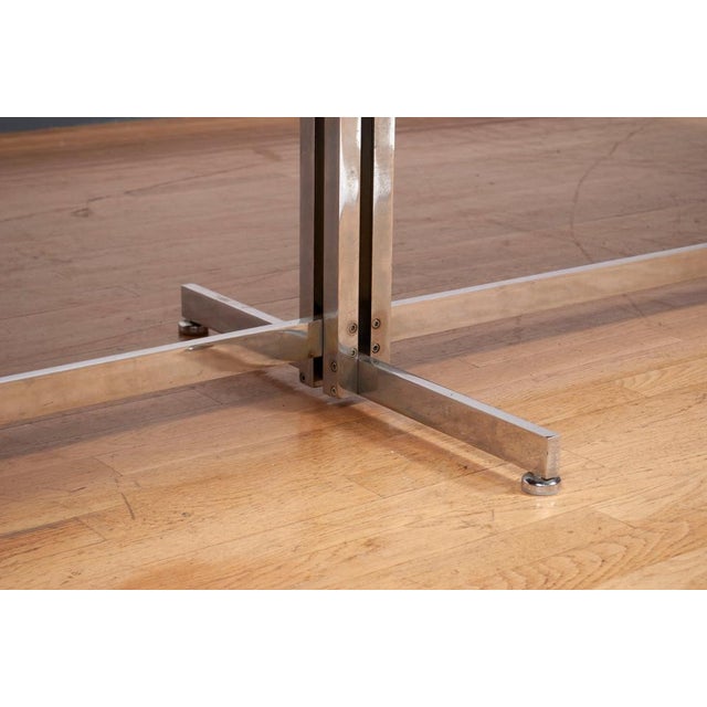 Attributed to - A heavy steel and chrome base supports an ovular laminate rosewood top that at its widest in the middle is...
