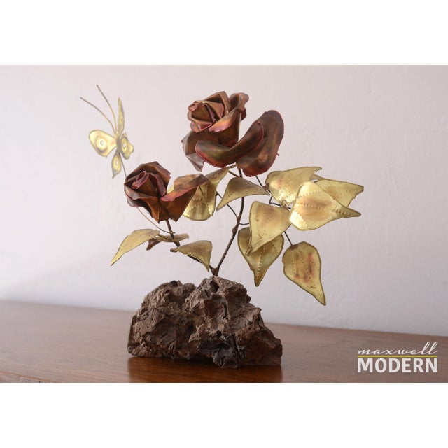 Gorgeous vintage metal sculpture of a rose plant with two roses and a butterfly on a burl wood base. The roses are enamel...